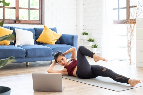 Genç Asyalı sağlıklı kadın antrenmanı evde, egzersiz, formda, yoga yapıyor, spor yapıyor.
