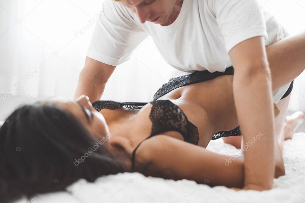 Nude passionate couple having sex on white bed, love and sex concept