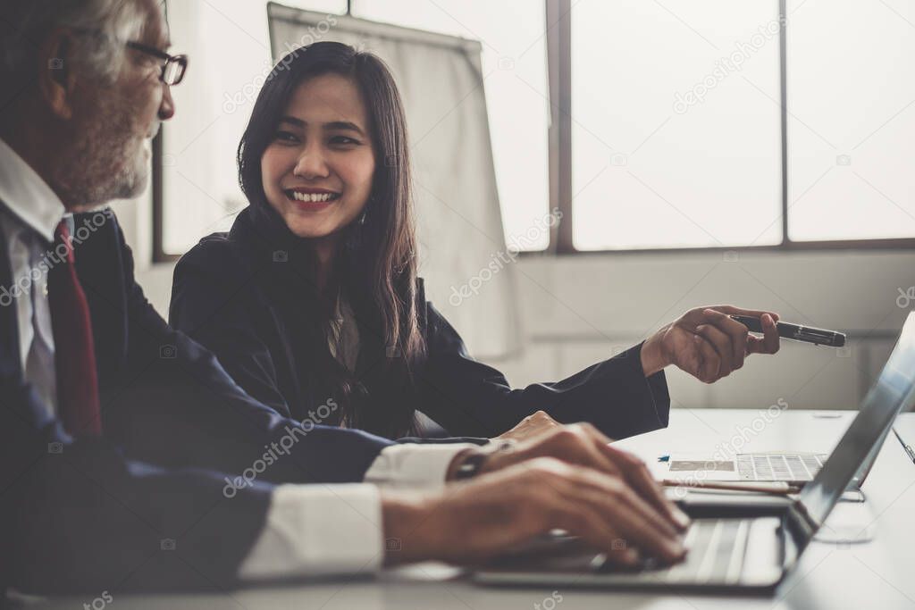 Business people discussing while meeting in office, working with laptop