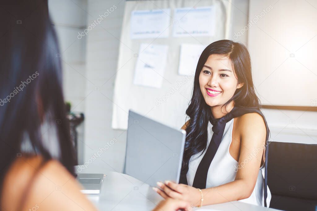 Young asian businesswoman in modern office, discussing with colleague and during meeting