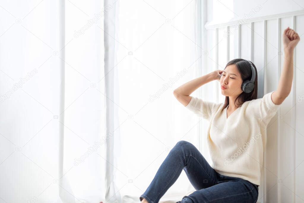 Young beautiful Asian woman listen song music at home, happy lifestyle concept