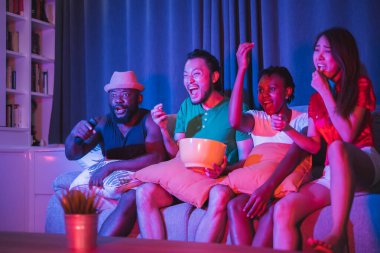 Bir grup çeşitlilik. Arkadaşları evlerinde neşeli bir şekilde futbol maçı izleyip eğleniyorlar.