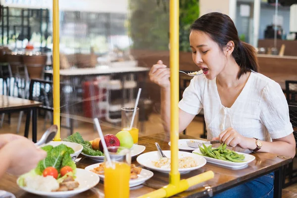 Азиатская Женщина Сидящая Отдельно Ресторане Ест Еду Столом Щита Пластиковые — стоковое фото