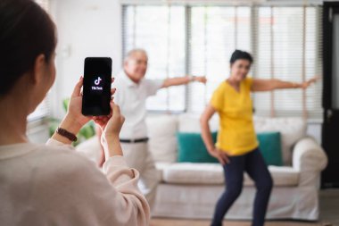 1-Jun-2020, Bangkok, Tayland: Cep telefonu kullanan Asyalı kadın yaşlı insanların tiktok uygulamasında dans ederken videosunu çek