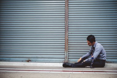 Asyalı işadamı iş yerinde oturmaktan, işsizlikten, işten kovulmaktan, hayal kırıklığına uğramaktan, kaybetmekten ve moralinin bozulmasından bıktı.