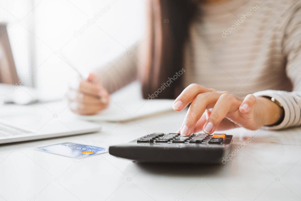 Woman accountant working with computer and calculator for business and financial expense