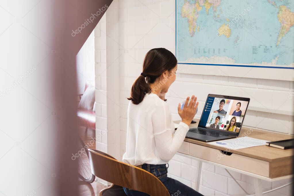 Young Asian businesswoman work at home and virtual video conference meeting with colleagues business people, online working, video call due to social distancing at home office