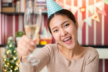 Video konferansında kutlama yapmak için şarap bardağı tutan Asyalı kadın doğum günü ve evde yeni yıl partisi için yeni normaller.