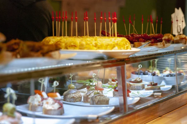 Assortment of skewers and tapas in restaurant display. Omelet of potatoes, montaditos