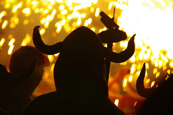 Kontrast maskeli şeytan kostümü, adam ayakta ve havai fişek ve haşhaş havai fişek festivalinde