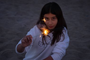 Sahilde günbatımı sırasında genç göz bazı bengals elinde tutarken