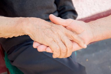 Yaşlı çift el tutuyor. Yaşlı insanların birbirlerine ihtiyacı var..