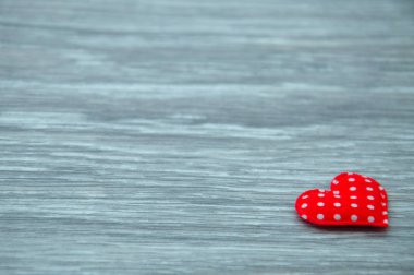 Ahşap masada kırmızı kalp. Aşk beyanı. Gri bir arka planda yalnız kalp.