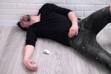 The guy is lying on the floor with an overdose of drugs. A young guy committed suicide at home. clipart