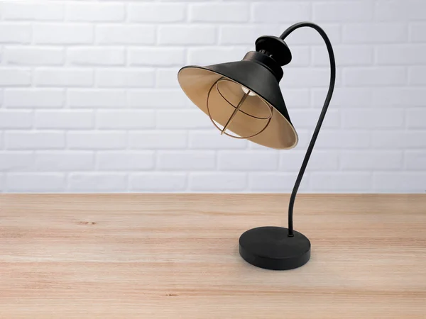 Vintage black lamp on the table against the background of the white loft.