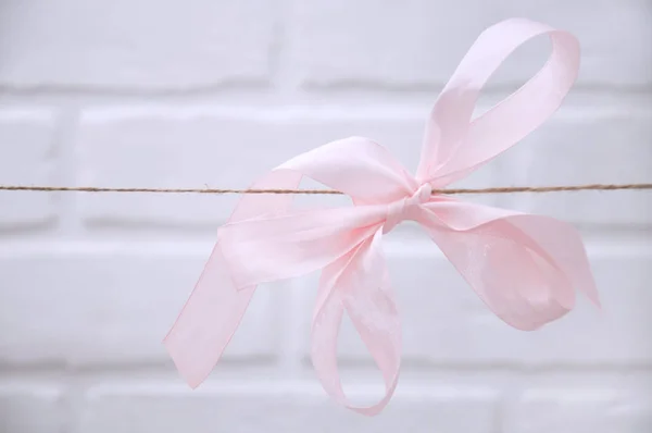 Rosa Seidenschleife Die Einem Seil Auf Weißem Hintergrund Hängt Glückwunschkarte — Stockfoto