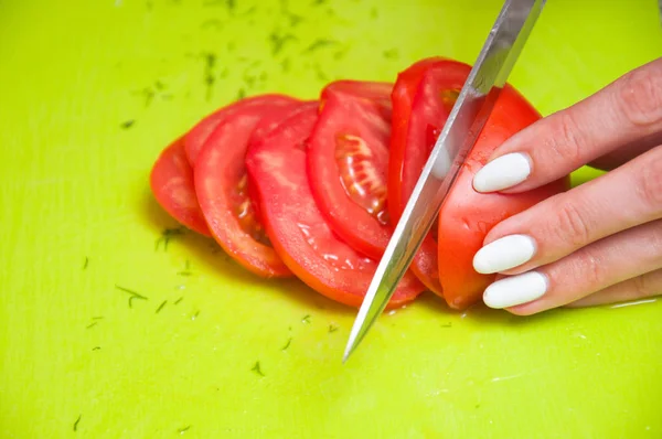 소녀는 보드에 토마토를 슬라이스 슬라이스 토마토 클로즈업 — 스톡 사진