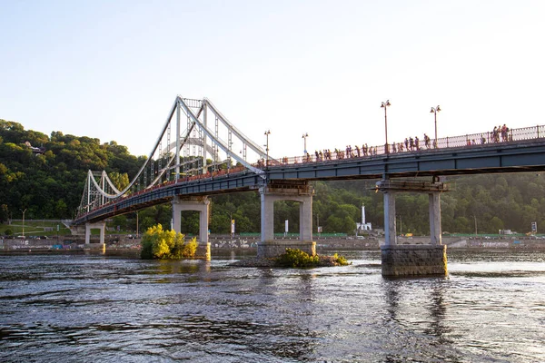 Dnipro nehri üzerindeki yaya parkı köprüsü, Kyiv, Ukrayna. Köprüde bir sürü insan var, dışarıda. Ukrayna 'da yaz