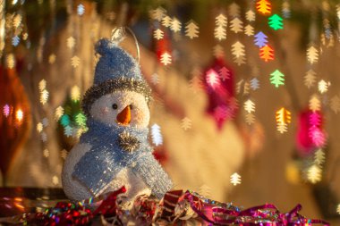 Xmas oyuncağı Kardan Adam 'a yakın. Sıcak ışık, bulanık ve noel ağacı arka planı