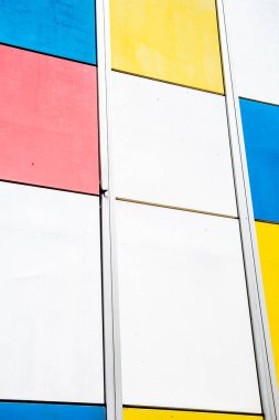 Renkli geometrik arka plan. Kırmızı, mavi, beyaz ve sarı renkli soyut arkaplan. Dikey görünüm