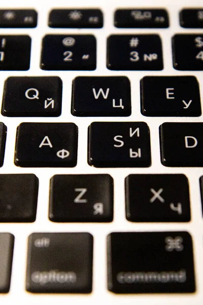 Siyah tuşlu, dikey manzaralı gümüş dizüstü bilgisayar klavyesi. İş konsepti