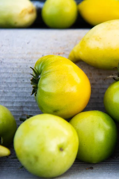 Sarı yeşil domatesli doğal bir arka plan. Taze vejetaryen yemeği. Sonbahar atmosferi. Dikey görünüm