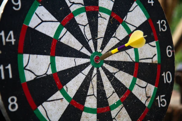 Close up view to darts in bull's eye. One yellow darts arrows in the target center, business goal concept