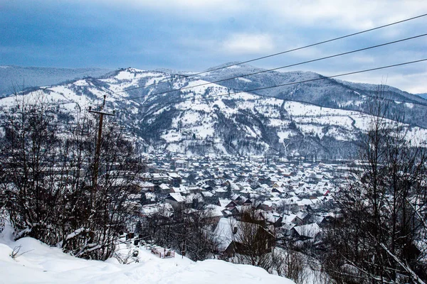 Kış dağları mavi gökyüzü, ağaçlar, köy ve bir sürü karla kaplı. Kış arkaplanı