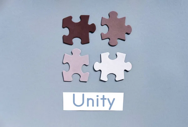 Pedaços de puzzle coloridos em fundo cinza vista superior. Concept for Unite para acabar com o racismo. Símbolo de associação e conexão, estratégia de negócios, suporte de equipe e conceito de ajuda . — Fotografia de Stock