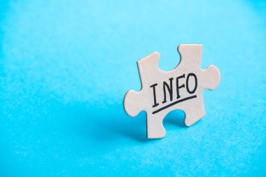 Üzerinde INFO yazıları olan bulmaca parçası parlak mavi bir arkaplanda duruyor. Ortaklık ve bağlantı sembolü, iş stratejisi, tamamlama, takım desteği ve yardım kavramı.