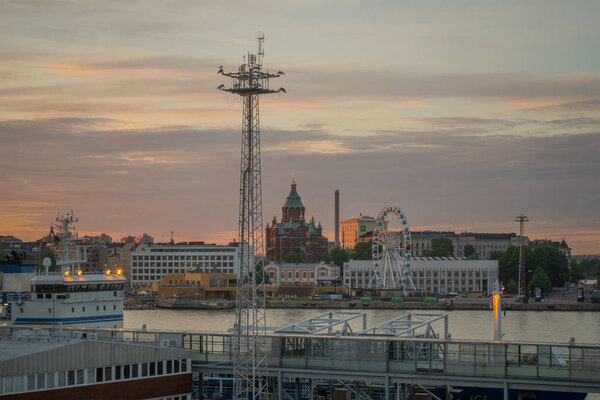 Sunset view of the south harbor, with the Russian Orthodox Uspenski Cathedral, and the SkyWheel, in Helsinki, Finland