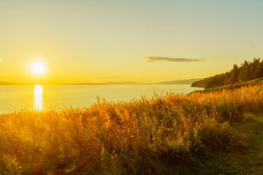 Sunset view of shore and ocean in the south sector of Forillon National Park, Gaspe Peninsula, Quebec, Canada clipart