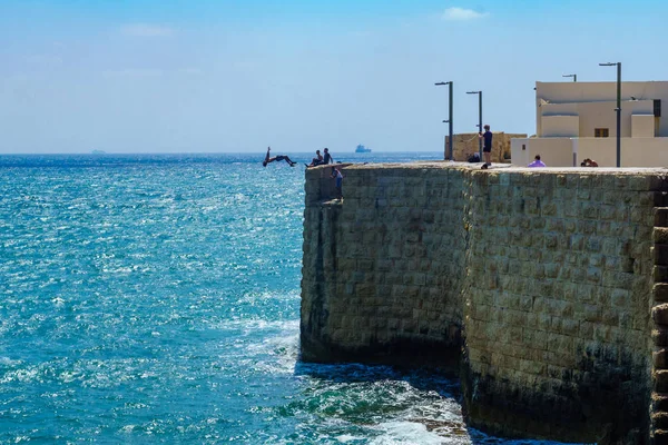 Jonge man springen van de muur, in Acre — Stockfoto