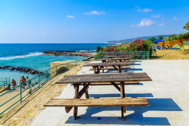 Achziv, İsrail - 22 Temmuz 2020: Kuzey İsrail 'deki Achziv ulusal parkında piknik masaları ve sahil manzarası