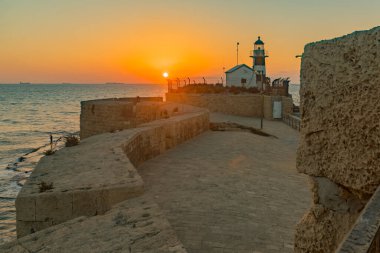 İsrail 'in Acre (Akko) kentindeki deniz fenerinin günbatımı manzarası