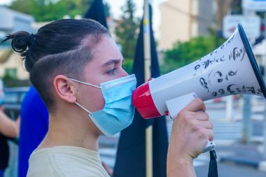 Hayfa, İsrail - Ekim 06, 2020: Megafonlu protestocu, evden 1 km uzaklıktaki protestocular, hükümete, Bibi Netanyahu 'ya ve Ziv merkez, Hayfa, İsrail' deki yakın tarihli tecride karşı protestolar