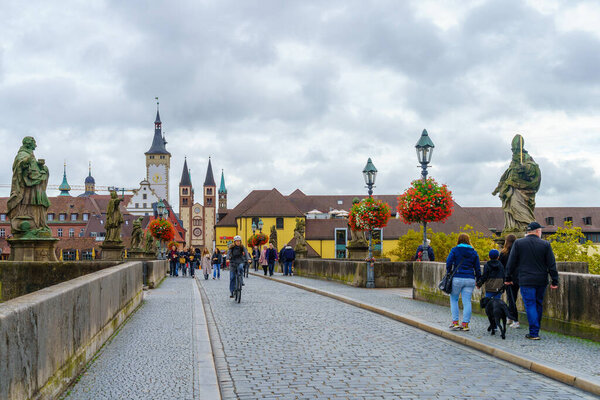 Вурцбург, Германия - 08 октября 2024 г.: Вид на Старый главный мост Alte Mainbrcke с местными жителями и посетителями в Вурцбурге, Бавария, Германия