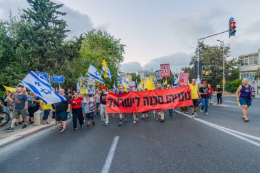 Hayfa, İsrail - 06 Eylül 2025: Çeşitli tabelaları ve bayrakları olan insanlar, savaşın sona ermesi, rehine anlaşmasının tamamlanması ve yeni seçimlerin başlatılması için düzenlenen protesto mitingine katıldılar. Hayfa, İsrail