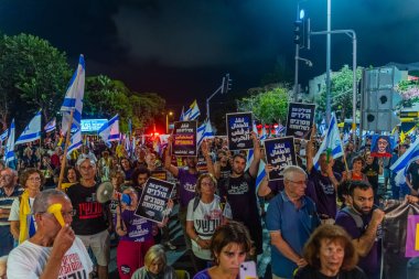 Hayfa, İsrail - 06 Eylül 2025: Çeşitli tabela ve bayraklara sahip bir grup insan, savaşın sona ermesi, rehine anlaşmasının tamamlanması ve yeni seçimler için düzenlenen protesto mitingine katıldı. Hayfa, İsrail