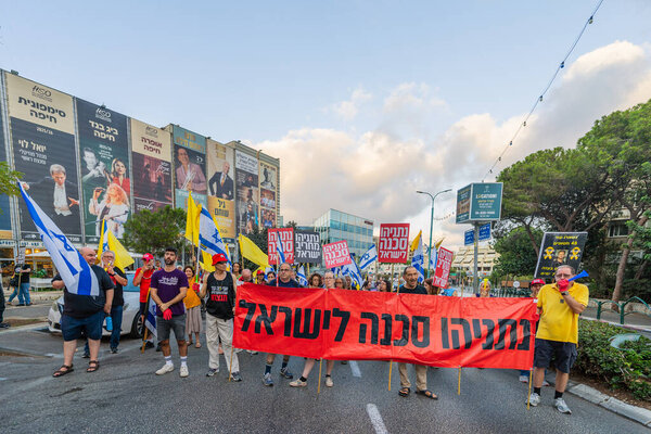 Haifa, Israel - September 06, 2025: People with various signs and flags take part in a protest rally calling for end the war, completion of the hostage deal and new elections. Haifa, Israel