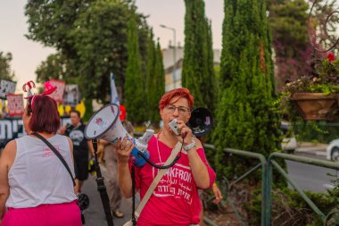 Hayfa, İsrail - 13 Eylül 2025: İnsanlar savaşın sona ermesi, rehine anlaşmasının tamamlanması ve yeni seçimler çağrısında bulunan bir protesto yürüyüşüne (Pembe Cephe Grubu) katılıyor. Hayfa, İsrail
