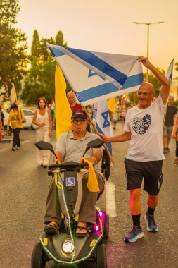 Hayfa, İsrail - 13 Eylül 2025: Çeşitli tabelaları ve bayrakları olan insanlar, savaşın sona ermesi, rehine anlaşmasının tamamlanması ve yeni seçimlerin başlatılması için düzenlenen protesto mitingine katıldılar. Hayfa, İsrail