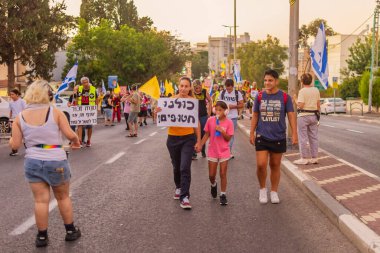Hayfa, İsrail - 13 Eylül 2025: Çeşitli tabelaları ve bayrakları olan insanlar, savaşın sona ermesi, rehine anlaşmasının tamamlanması ve yeni seçimlerin başlatılması için düzenlenen protesto mitingine katıldılar. Hayfa, İsrail