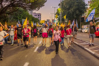 Hayfa, İsrail - 13 Eylül 2025: İnsanlar savaşın sona ermesi, rehine anlaşmasının tamamlanması ve yeni seçimler çağrısında bulunan bir protesto yürüyüşüne (Pembe Cephe Grubu) katılıyor. Hayfa, İsrail