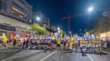 Hayfa, İsrail - 13 Eylül 2025: Çeşitli tabelaları ve bayrakları olan insanlar, savaşın sona ermesi, rehine anlaşmasının tamamlanması ve yeni seçimlerin başlatılması için düzenlenen protesto mitingine katıldılar. Hayfa, İsrail