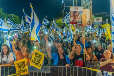 Hayfa, İsrail - 13 Eylül 2025: Çeşitli tabela ve bayraklara sahip bir grup insan, savaşın sona ermesi, rehine anlaşmasının tamamlanması ve yeni seçimler için düzenlenen protesto mitingine katıldı. Hayfa, İsrail