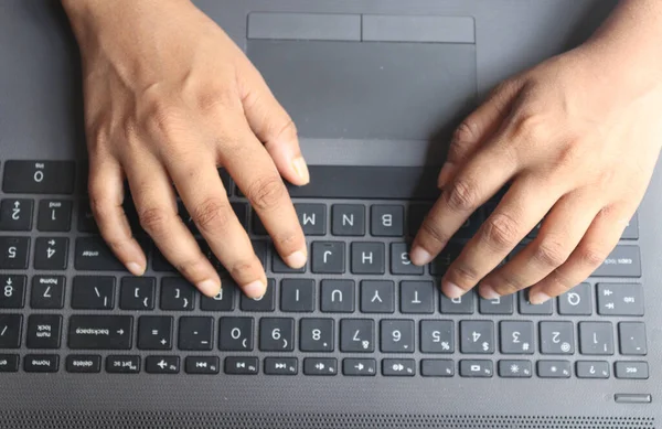 Dizüstü bilgisayarda çalışan insan elleri