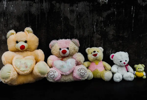 Oyuncak ayıcığın karanlık arka planında oynar