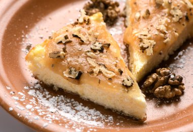 Kremalı cheesecake ve terasta tabağında parçalanmış ceviz..