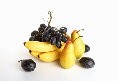 Beyaz arka planda muz, armut, erik ve üzümlerle dolu bir hayat.